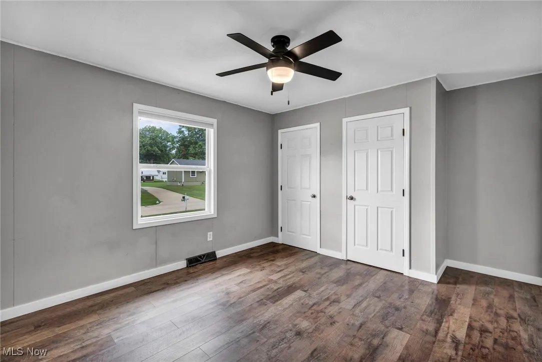 Unfurnished bedroom featuring wood finished floors and a ceiling fan