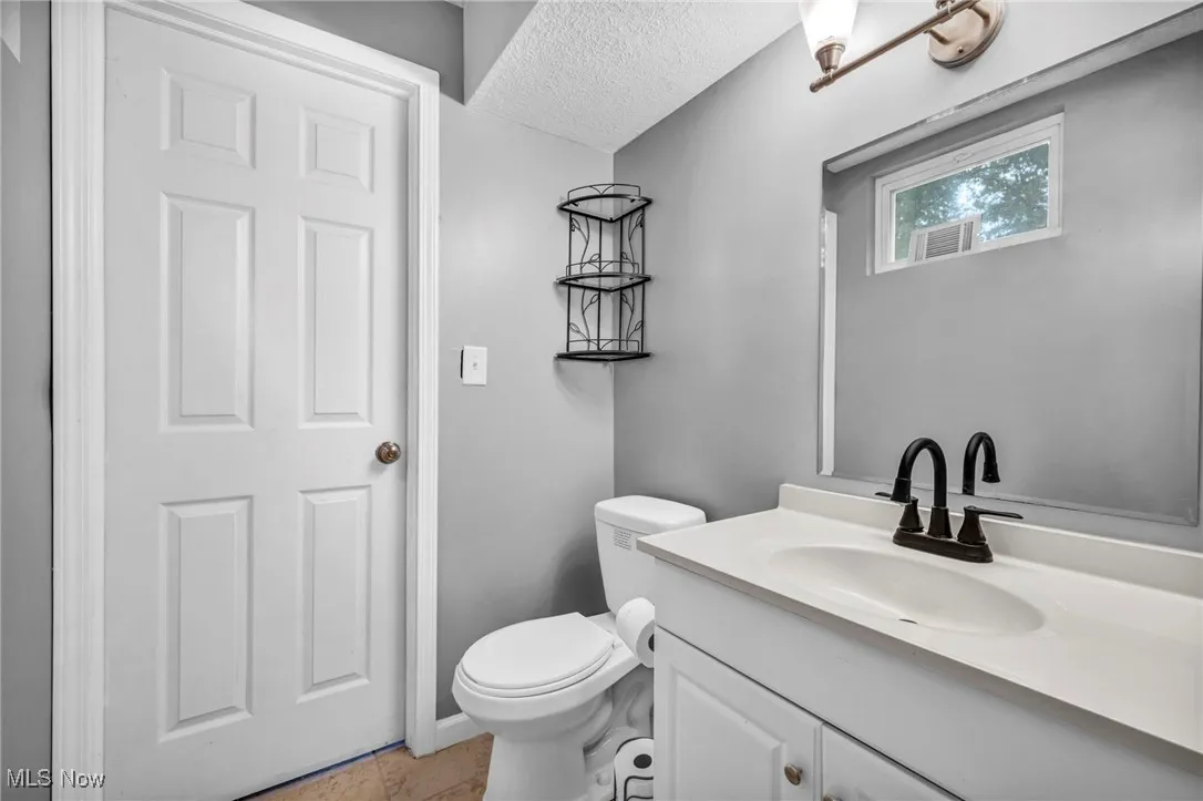 Bathroom featuring a textured ceiling, vanity, and tile patterned flooring