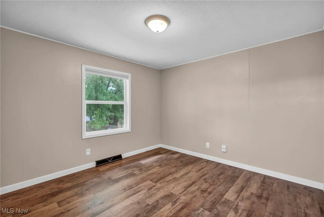 Spare room with wood finished floors and a textured ceiling