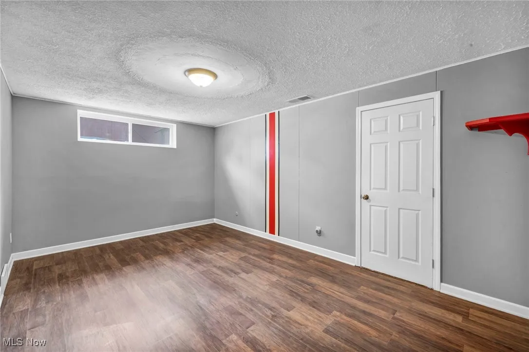 Unfurnished bedroom featuring a textured ceiling and wood finished floors