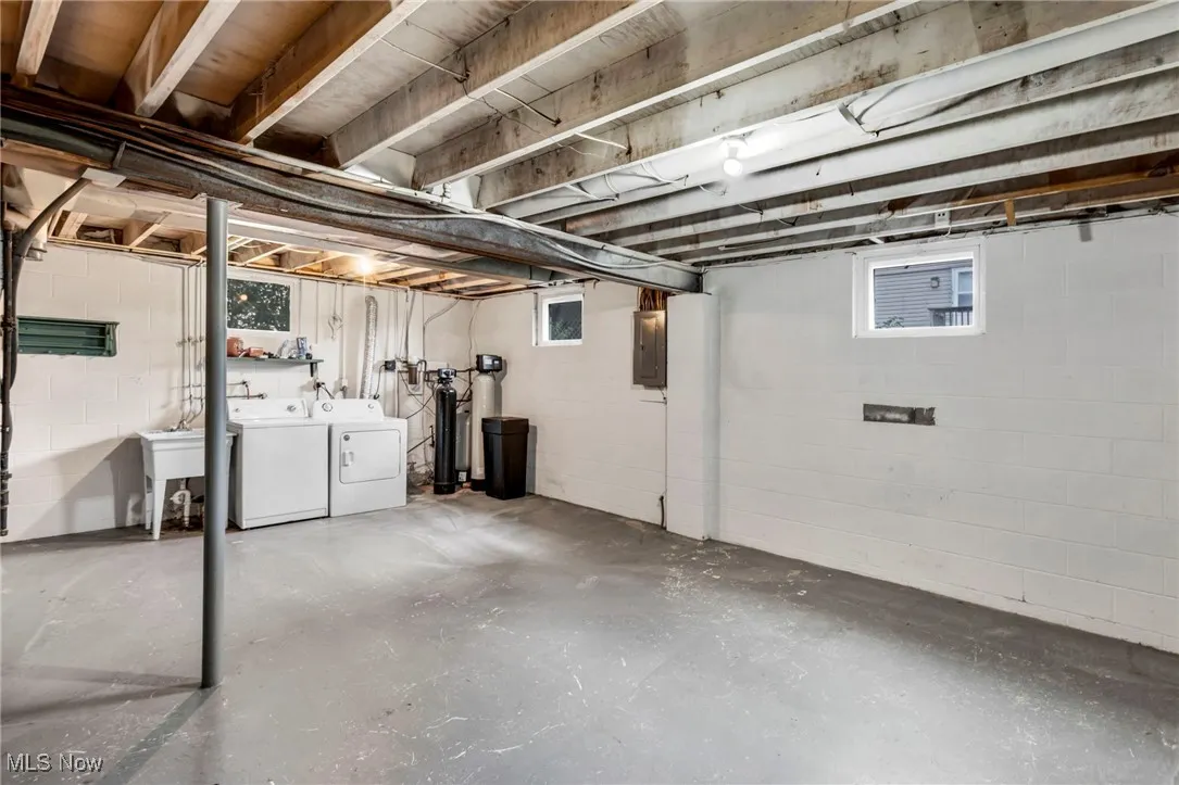 Below grade area with independent washer and dryer, a water softener system, and electric panel