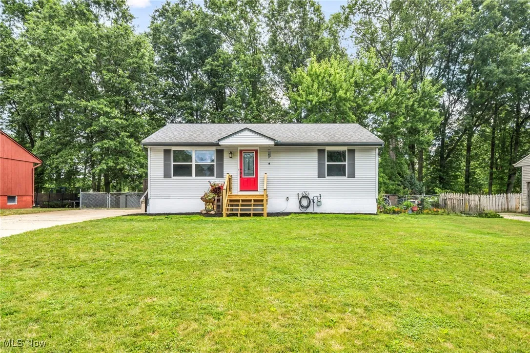 View of front of property featuring view of wooded area