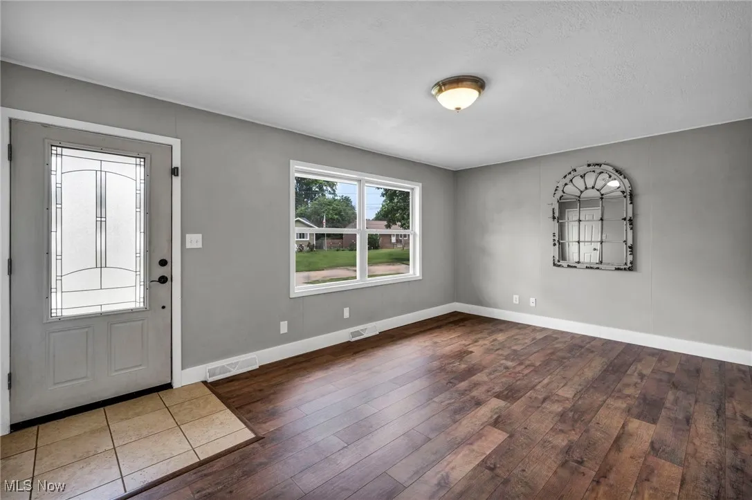 Foyer with wood-type flooring and a textured​​‌​​​​‌​​‌‌​‌‌​​​‌‌​‌​‌​‌​​​‌​​ ceiling