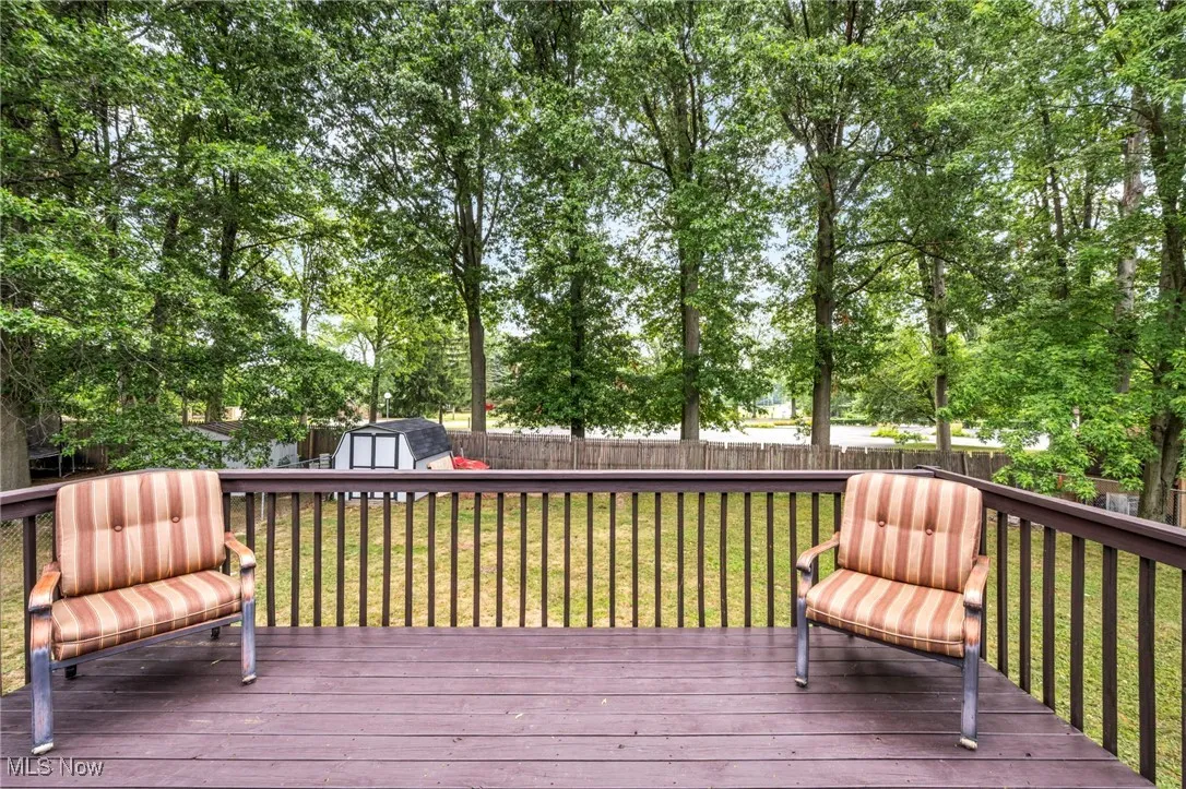 Wooden deck with a storage shed and a fenced backyard