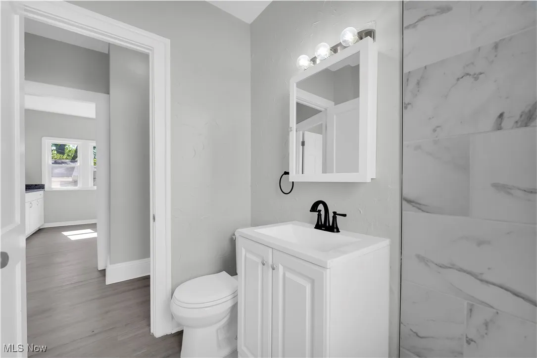 Bathroom featuring vanity, wood finished floors, and a textured wall