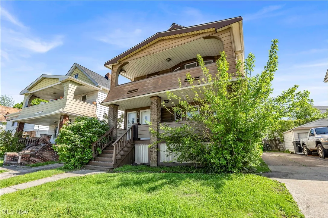 View of front of house with stairs, a balcony, a front yard, and a porch