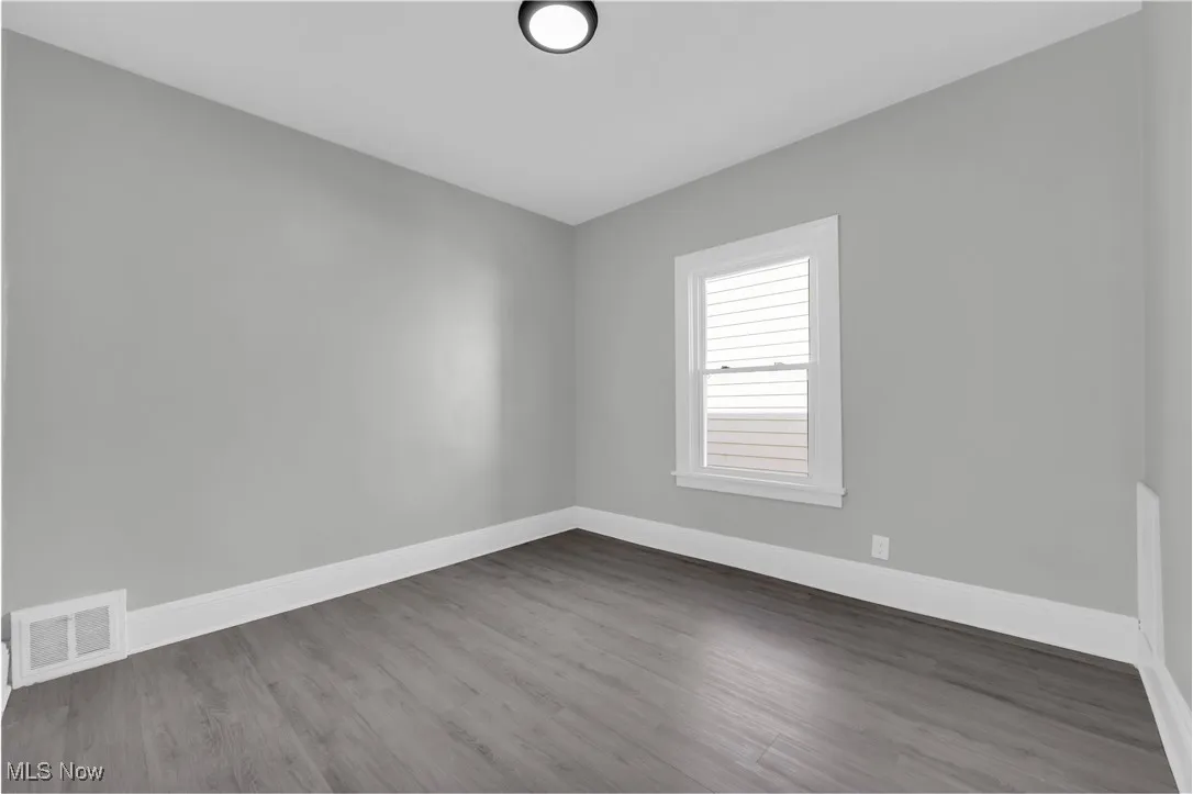 Empty room with dark wood-style flooring