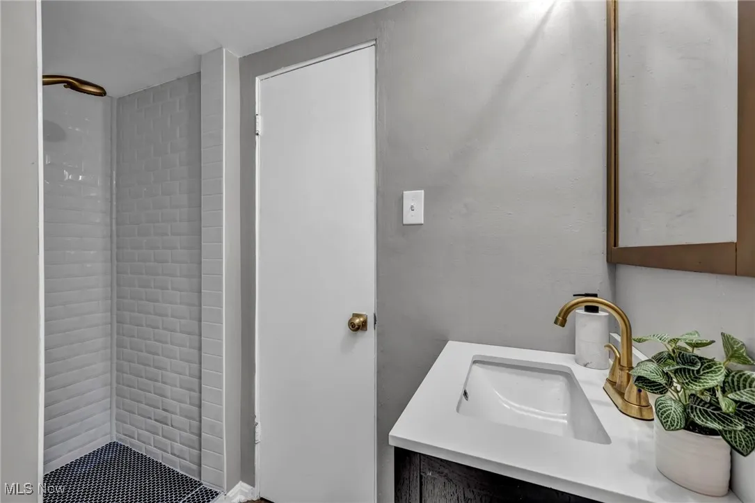 Bathroom featuring a tile shower and vanity