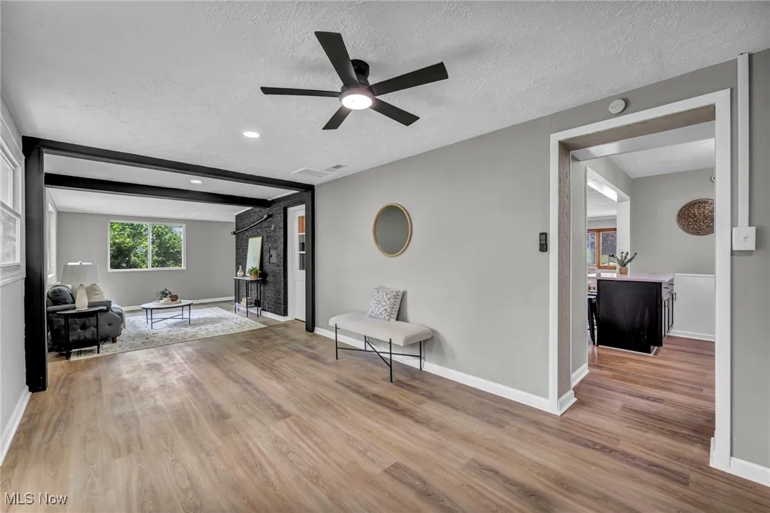Sitting room featuring wood finished floors, a textured ceiling, and ceiling fan