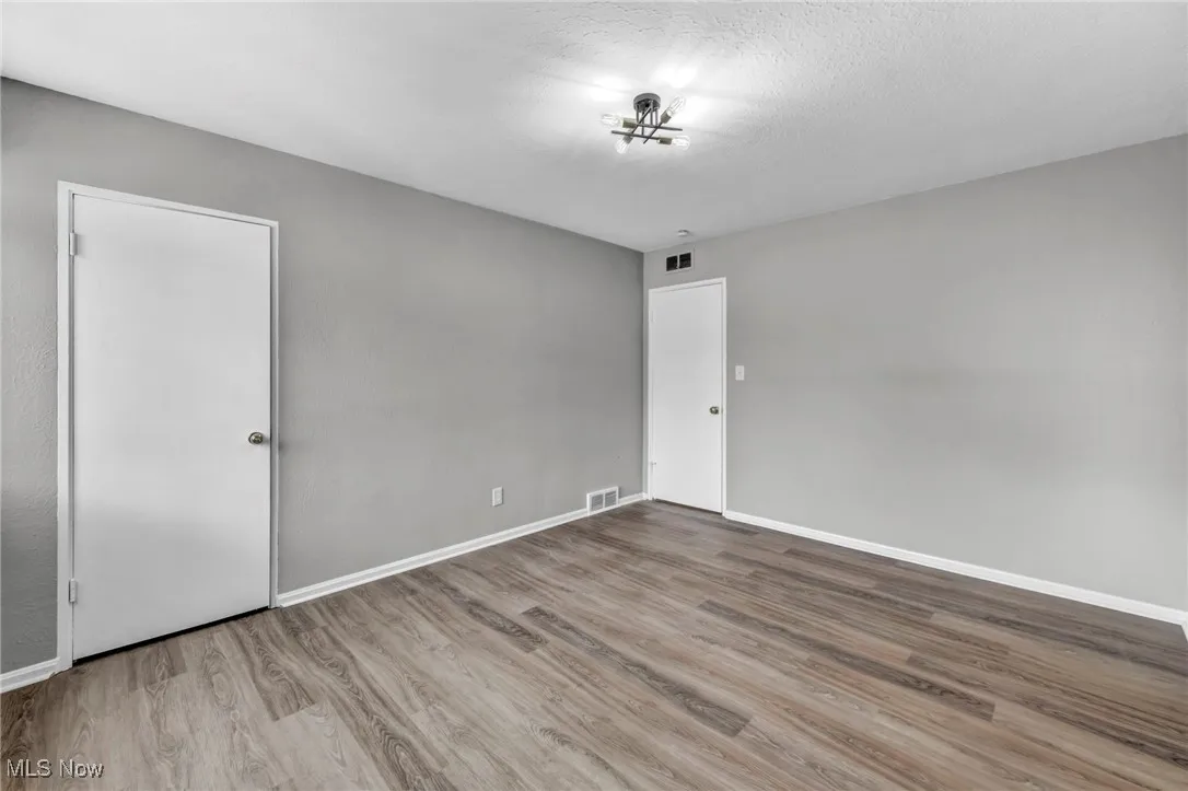 Spare room featuring wood finished floors and a textured ceiling