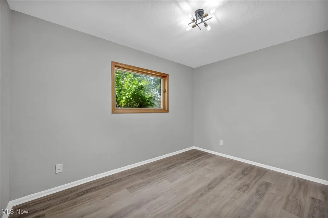 Spare room featuring wood finished floors and baseboards