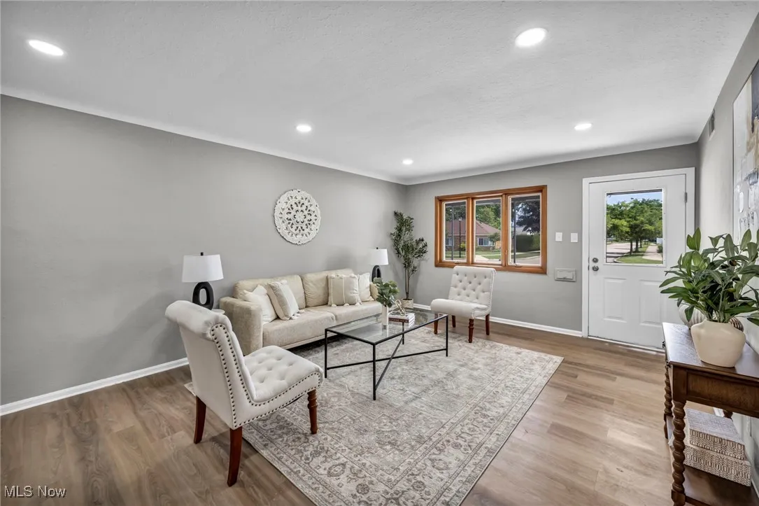 Living room featuring wood finished floors, recessed lighting, and crown molding