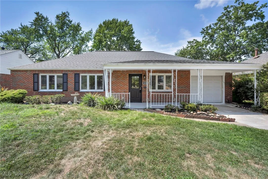 Single story home featuring a garage, concrete driveway, brick siding, and covered porch