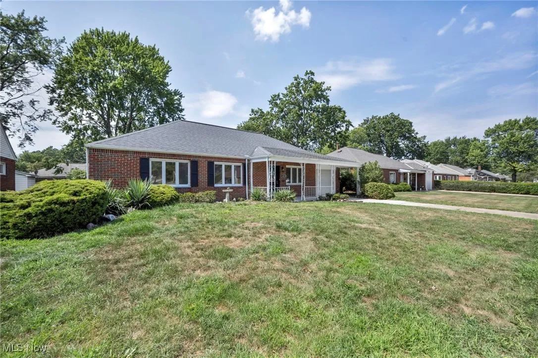 Single story home featuring brick siding and a front yard