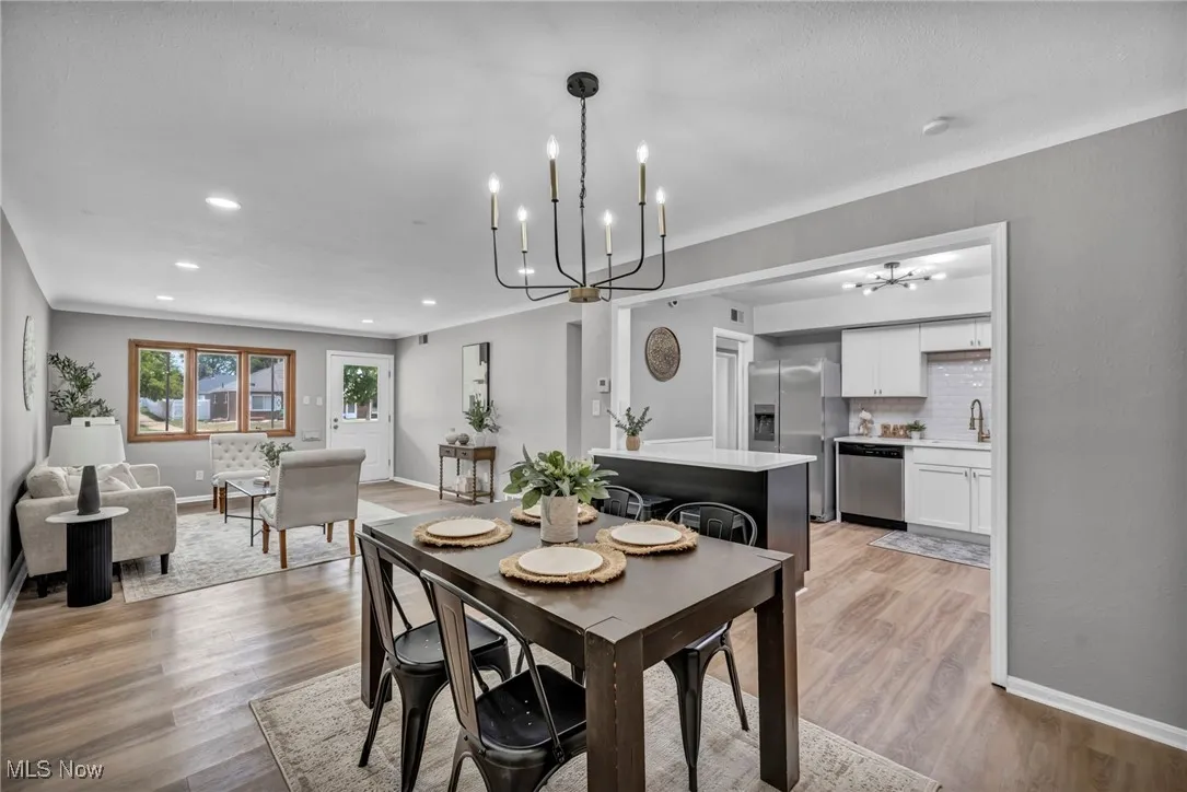 Dining space with a chandelier, light wood-style flooring, and recessed lighting