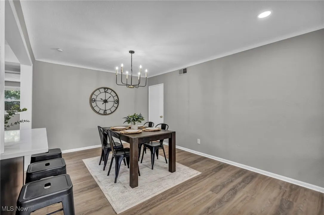 Dining room featuring wood finished floors, a chandelier, and ornamental molding