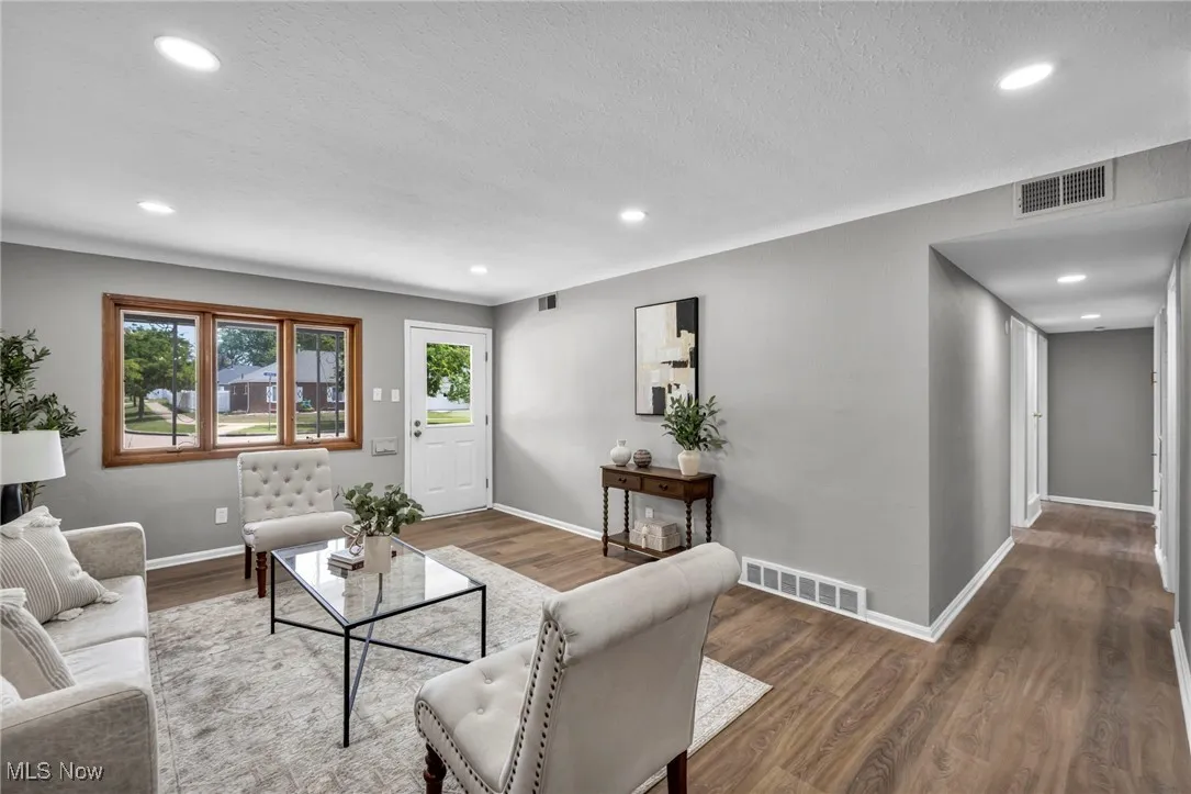 Living area with wood finished floors, recessed lighting, and a textured ceiling
