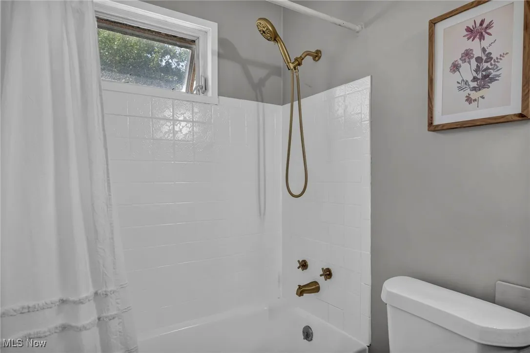 Full bath with shower / tub combo with curtain and toilet