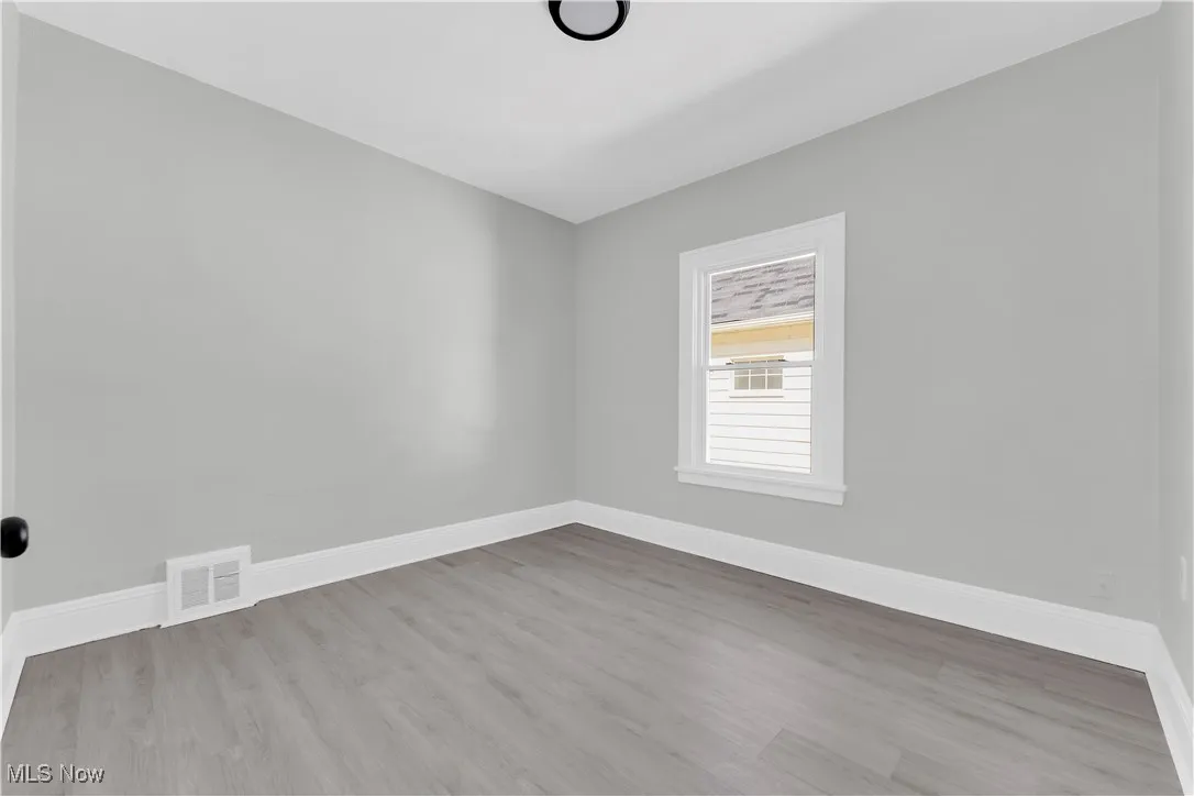 Spare room featuring baseboards and wood finished floors