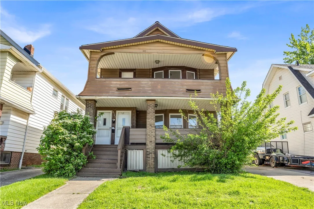 View of front of home featuring a front yard, a porch, and a balcony