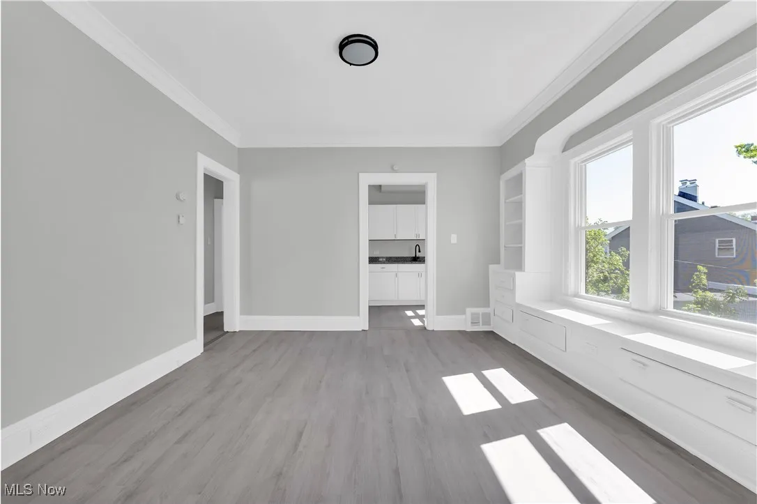 Unfurnished room featuring crown molding and wood finished floors