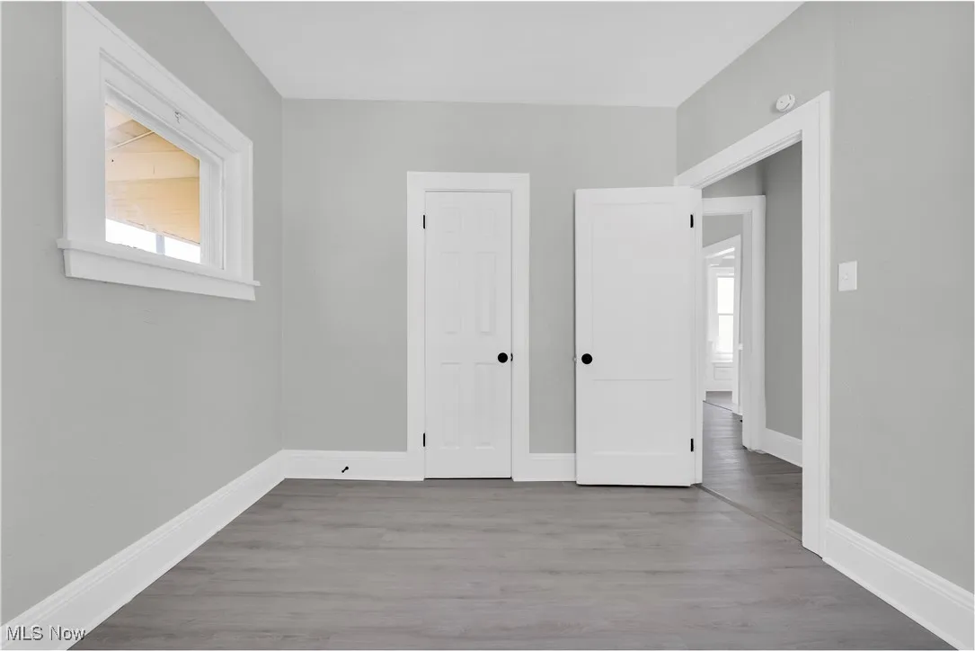 Unfurnished bedroom featuring wood finished floors and baseboards