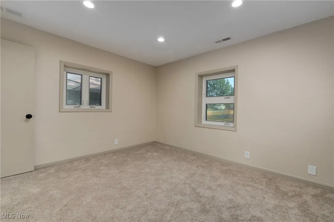 Carpeted empty room featuring recessed lighting and baseboards
