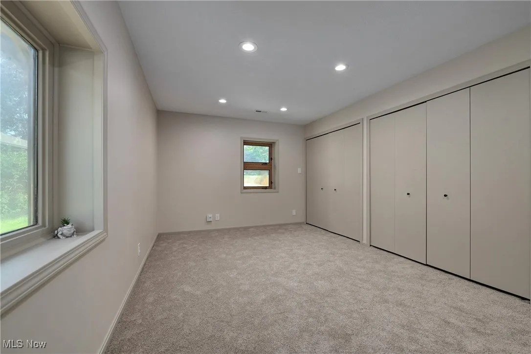 Unfurnished bedroom with two closets, carpet floors, and recessed lighting