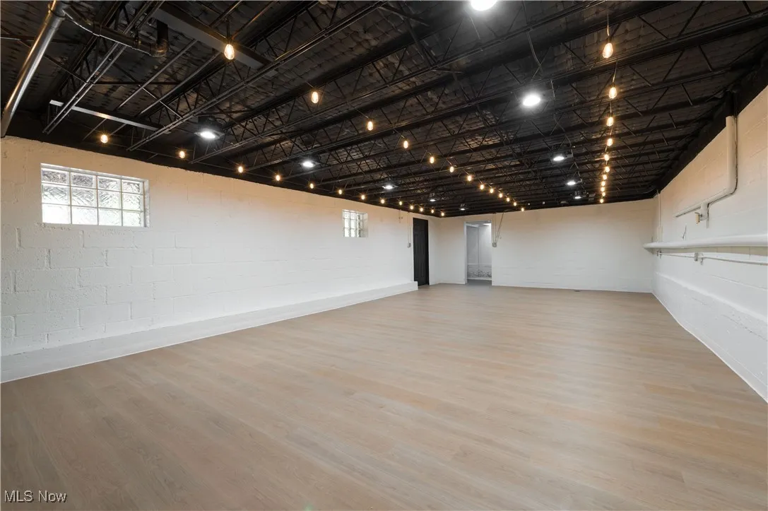 Below grade area with concrete block wall, wood finished floors, and plenty of natural light