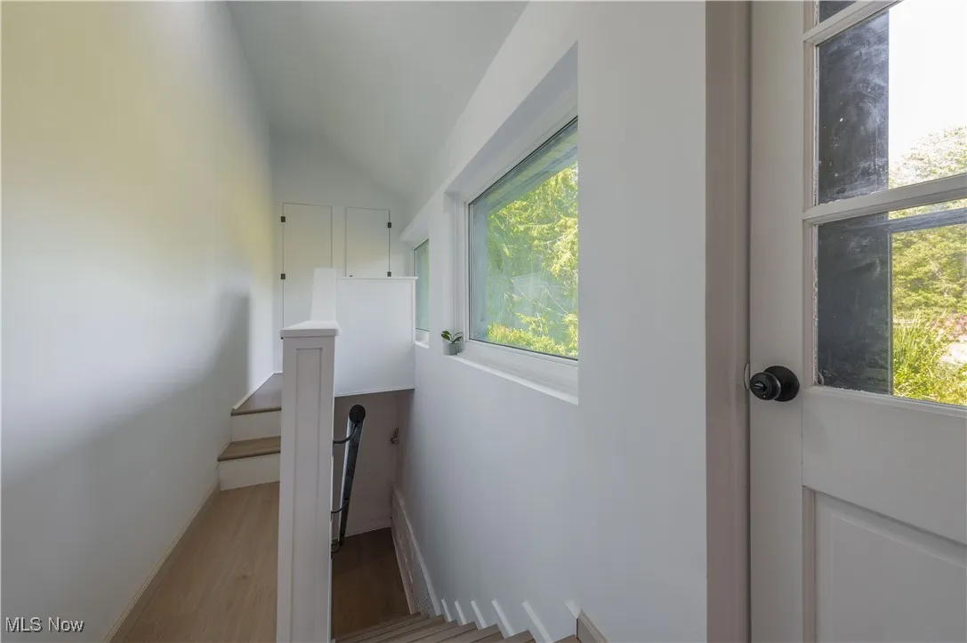 Stairs featuring lofted ceiling and wood finished floors
