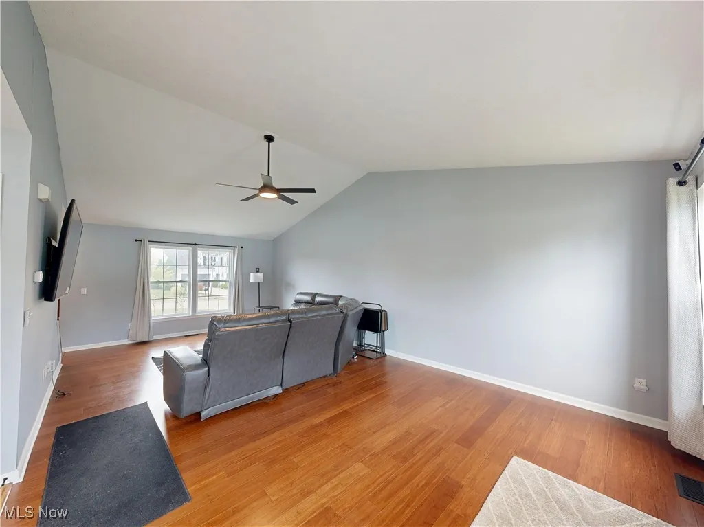 Living area with vaulted ceiling, light wood-type flooring, and ceiling fan