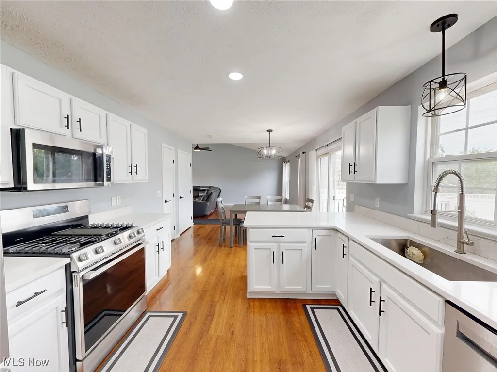 Kitchen featuring stainless steel appliances, light wood-style flooring, white cabinets, and recessed lighting