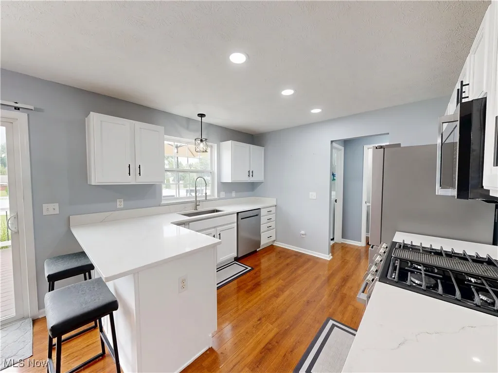 Kitchen featuring white cabinetry, light wood-style flooring, light countertops, and recessed lighting