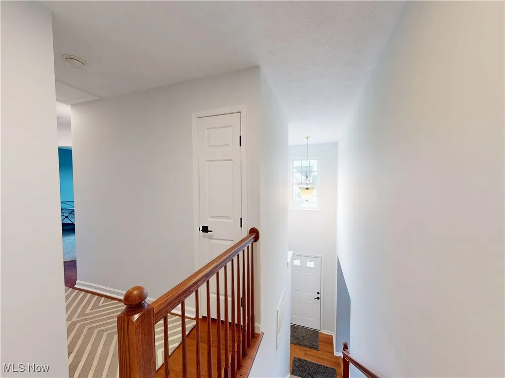 Stairway featuring wood finished floors and a textured ceiling