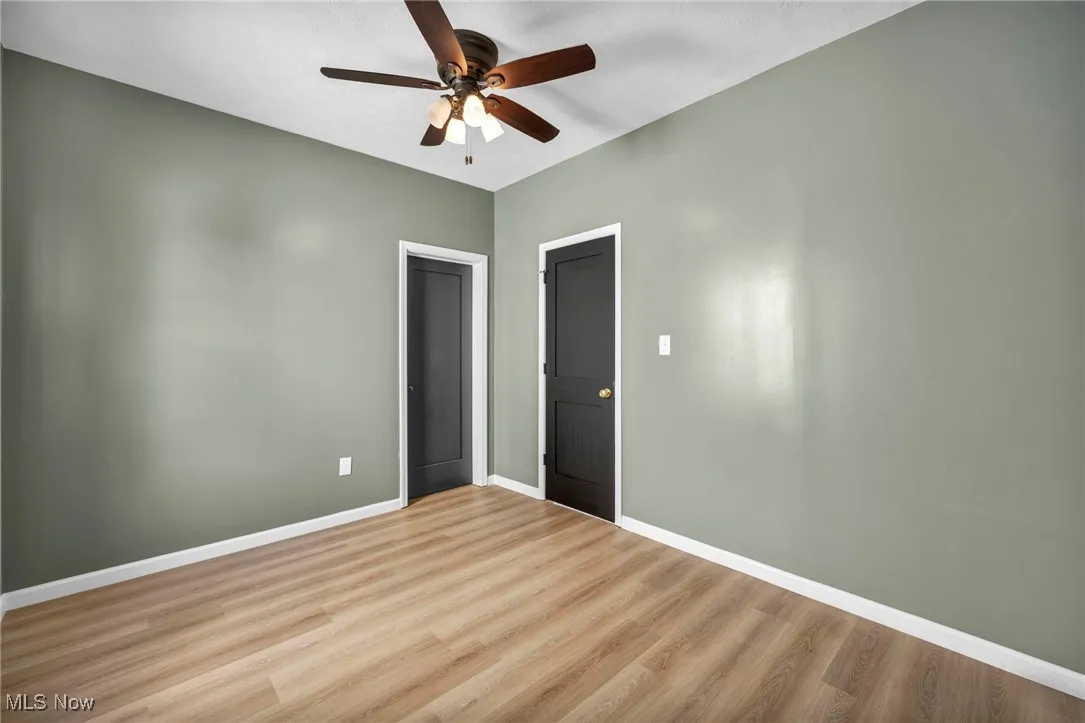 Unfurnished bedroom with wood finished floors and a ceiling fan