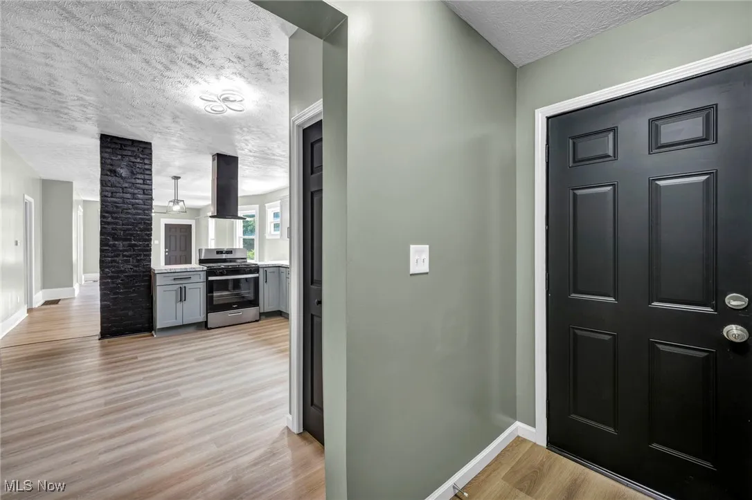 Foyer featuring a textured ceiling and light wood-type flooring