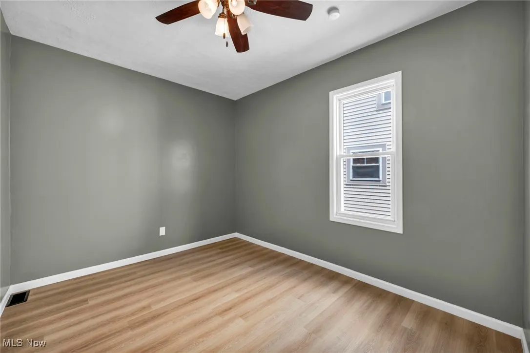 Spare room featuring wood finished floors and a ceiling fan