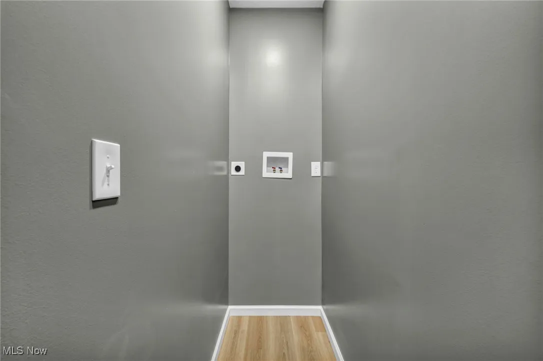 Washroom with electric dryer hookup, light wood-style flooring, and washer hookup