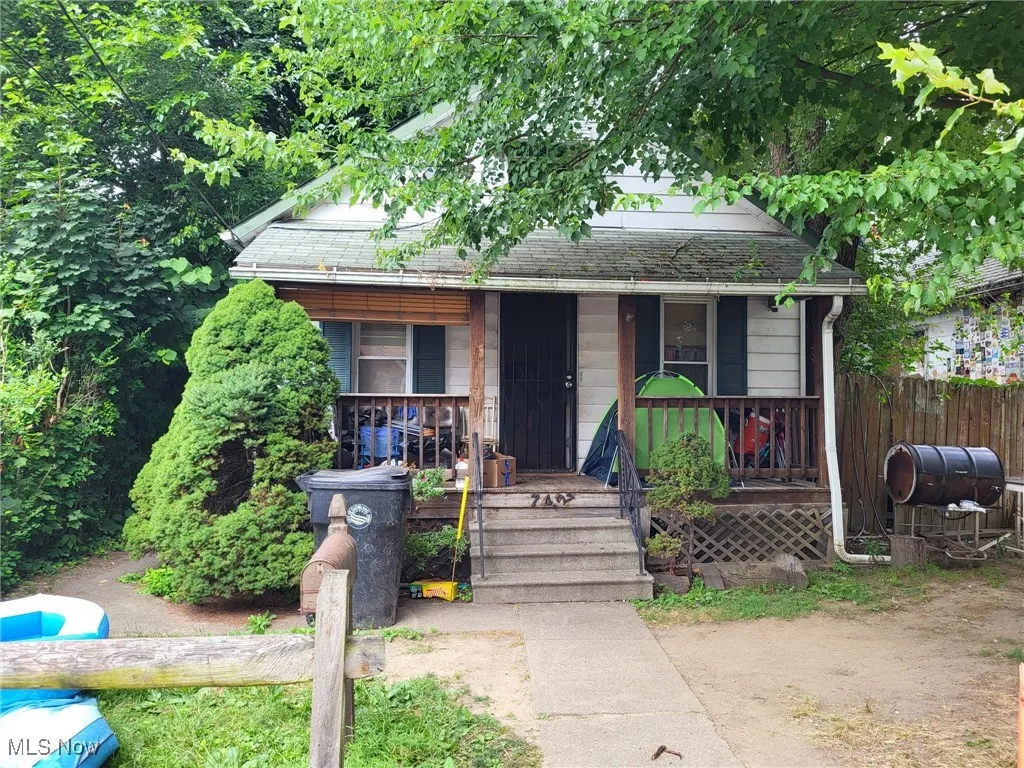 View of front of property with covered porch and roof with shingles