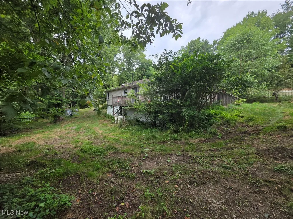 View of yard with a wooden deck and view of scattered trees