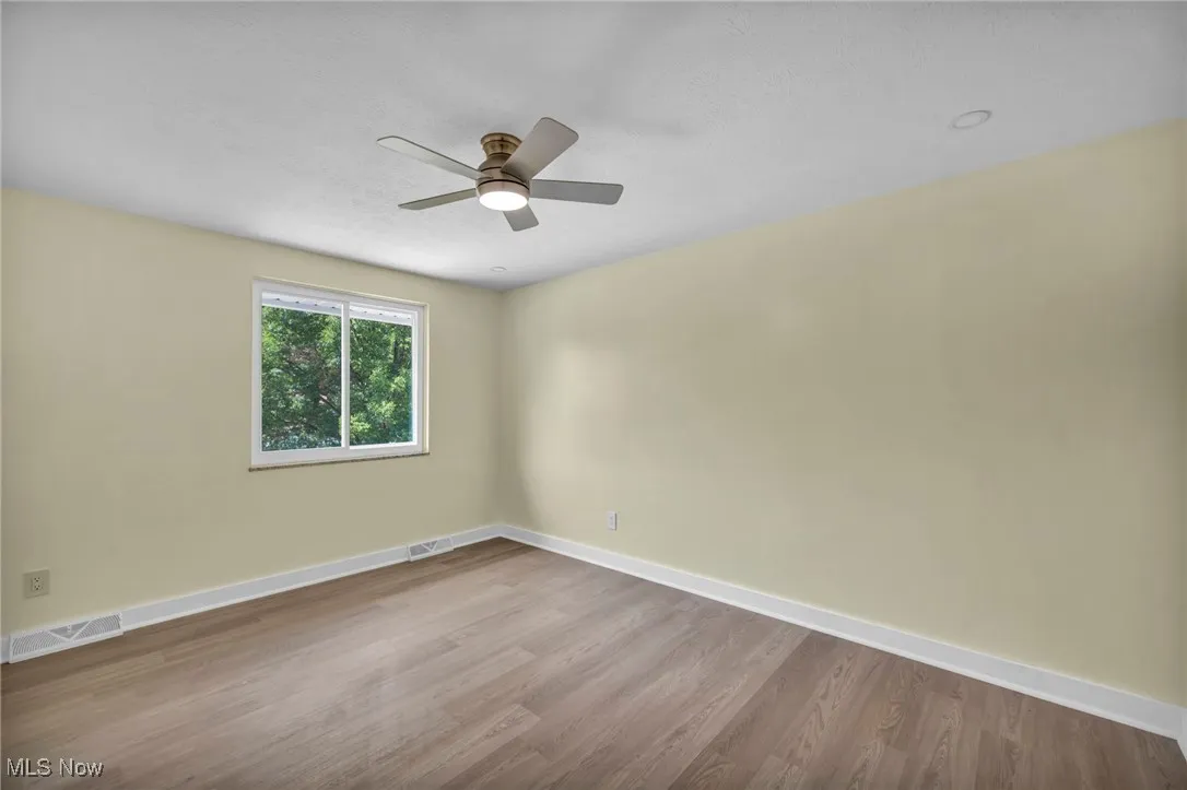 Empty room with wood finished floors, a textured ceiling, and a ceiling fan