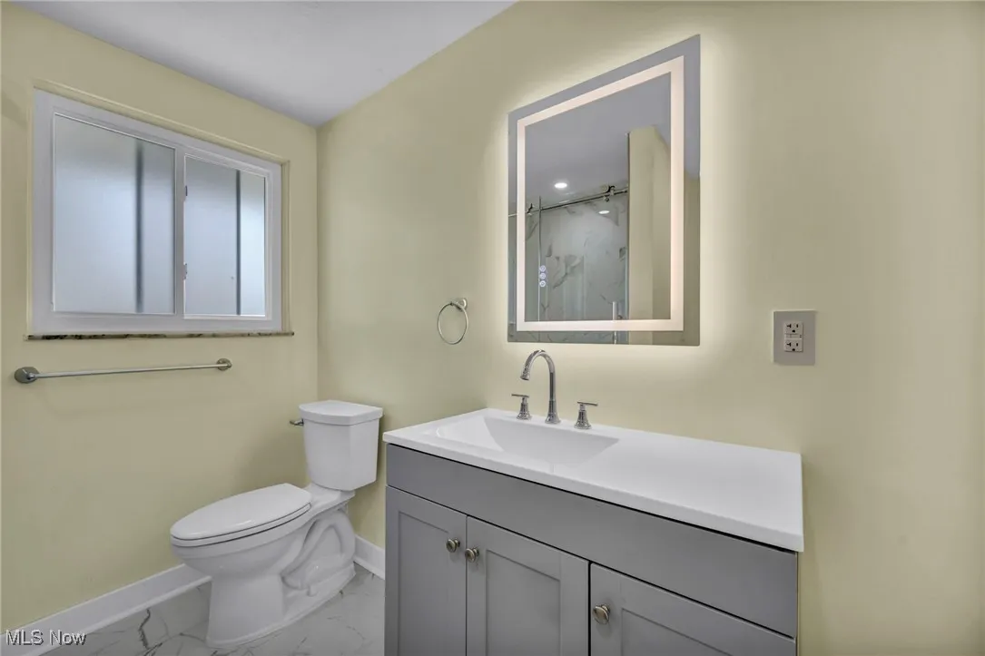Bathroom featuring marble finish floors, vanity, and a marble finish shower