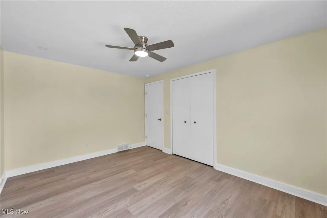Unfurnished bedroom featuring light wood-style flooring, a closet, and ceiling fan