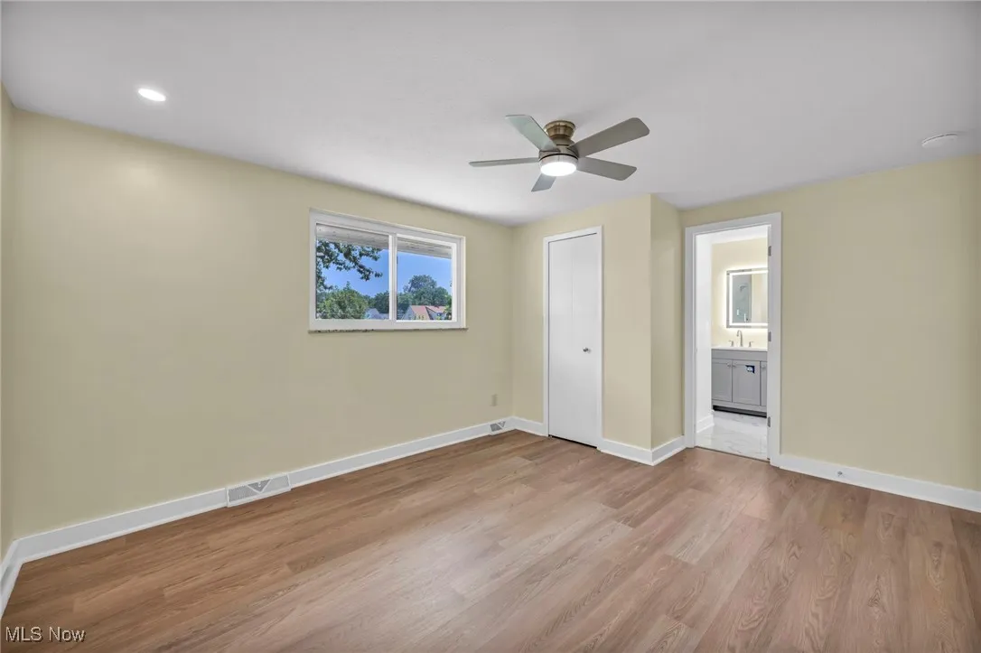 Unfurnished bedroom with light wood-type flooring, connected bathroom, a ceiling fan, a closet, and recessed lighting