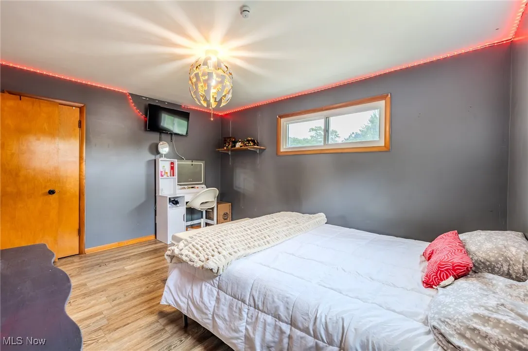 Bedroom with wood finished floors and a​​‌​​​​‌​​‌‌​‌‌​​​‌‌​‌​‌​‌​​​‌​​ chandelier