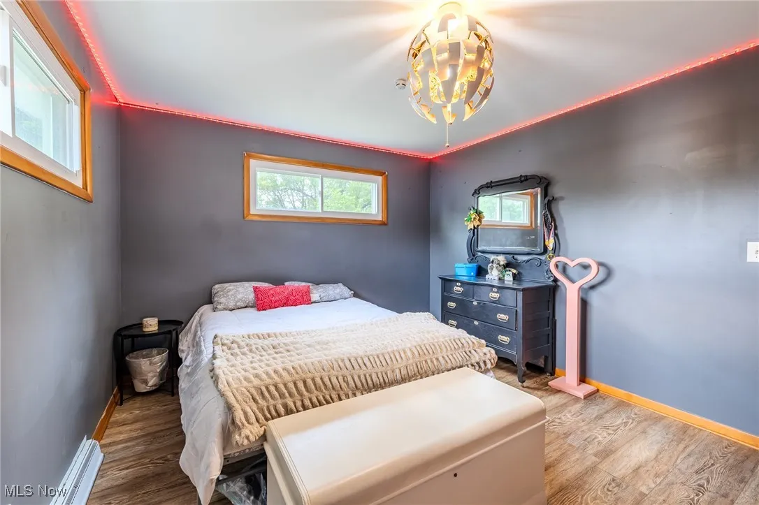 Bedroom featuring a baseboard radiator and light wood finished floors