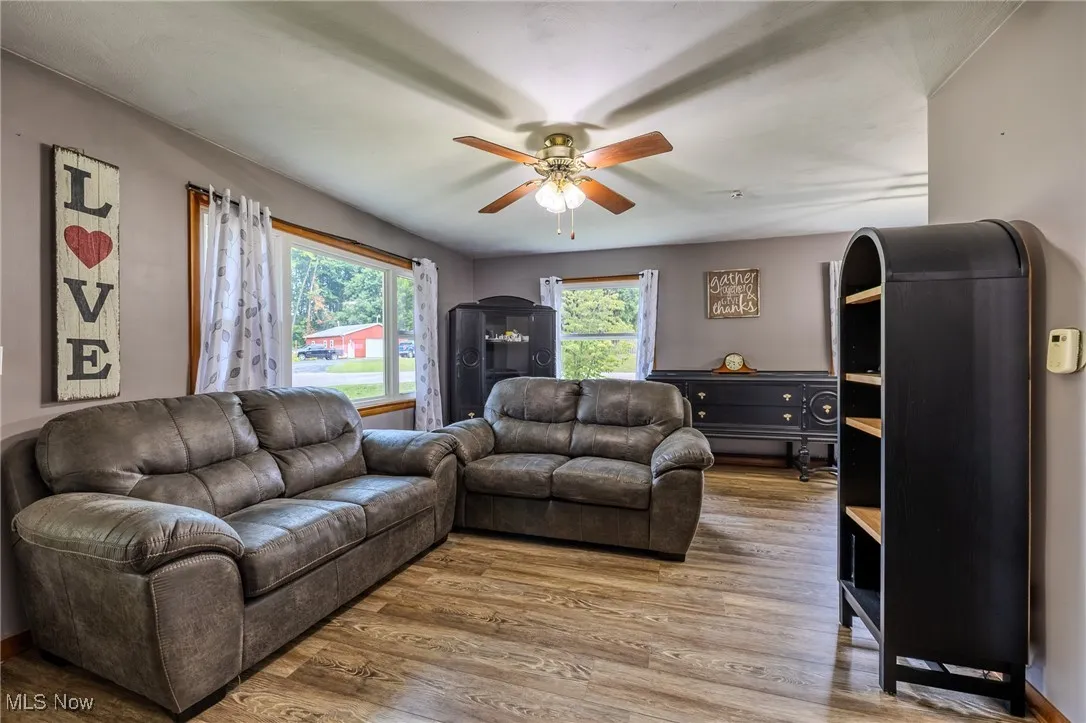 Living area featuring wood finished floors and a ceiling fan
