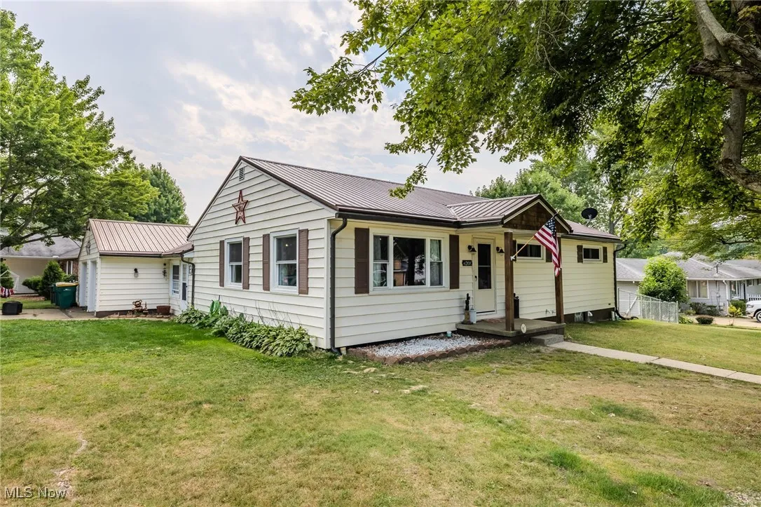 Single story home with a front yard and a metal roof