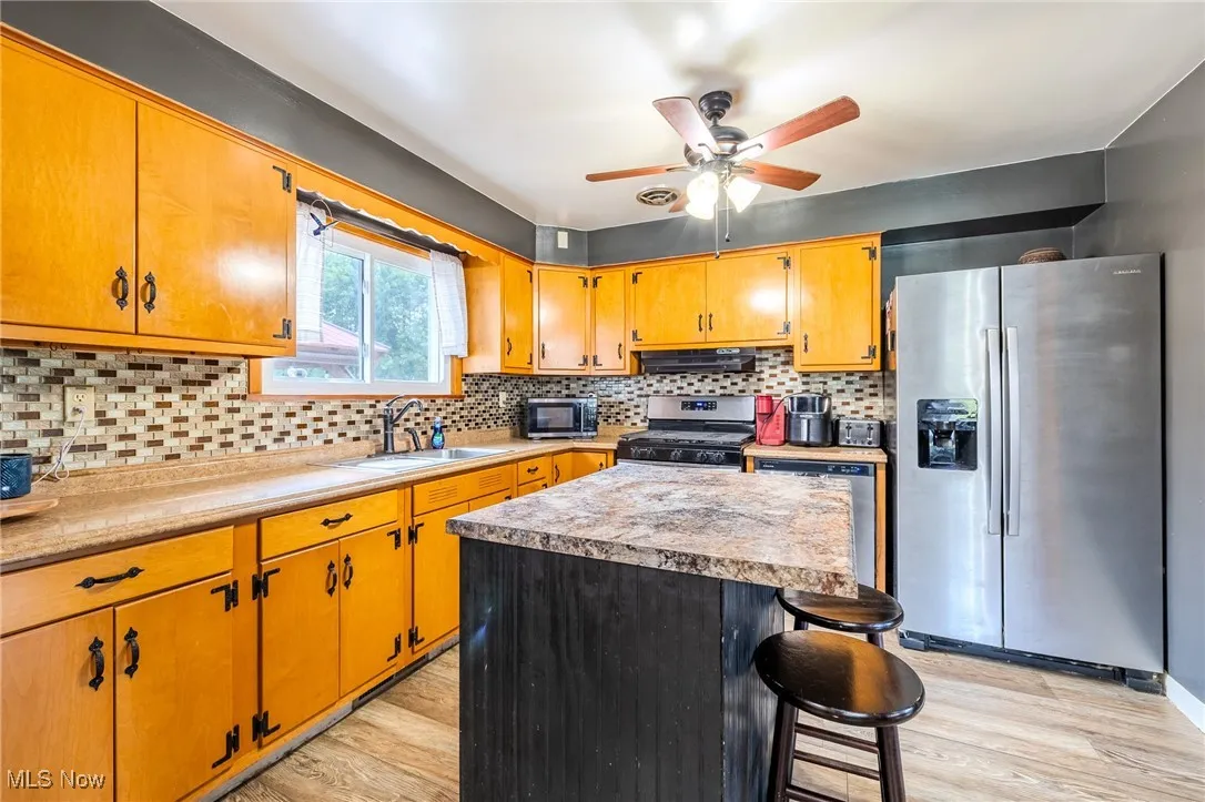 Kitchen featuring stainless steel appliances, backsplash, and light countertops
