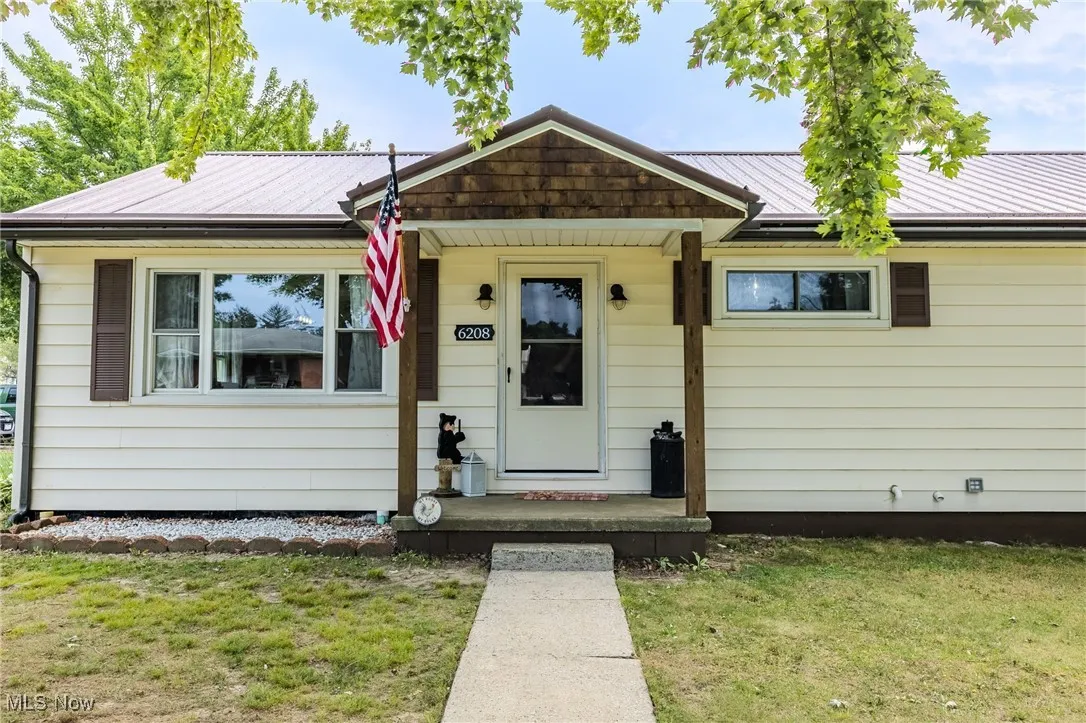 Ranch-style home featuring a front lawn and a metal roof